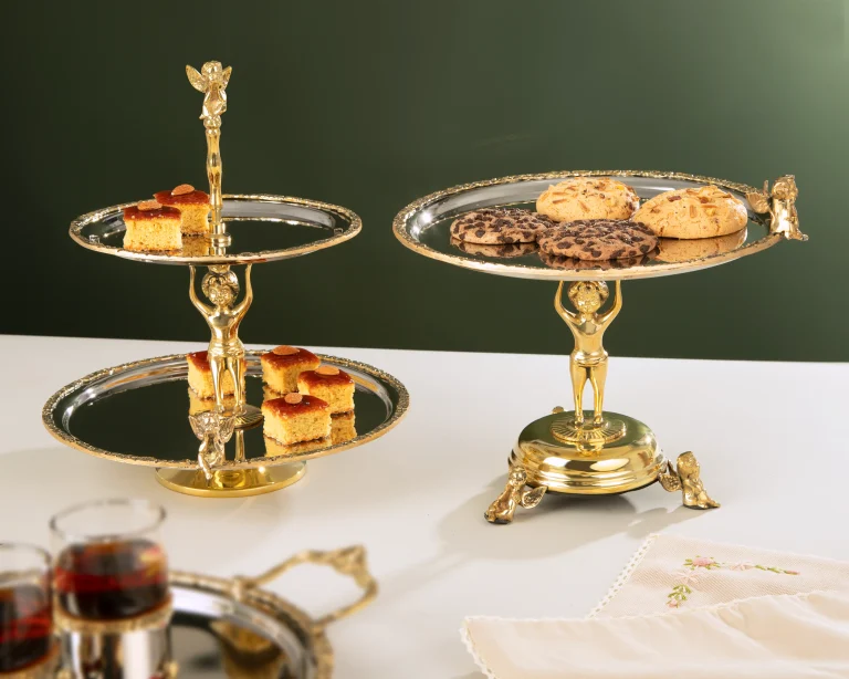 شیرینی‌خوری دو طبقه استیل و برنج تیارا مدل TI 4447 با طراحی پایه‌دار طلایی و سینی‌های استیل براق، مناسب پذیرایی و دکوراسیون لوکس منزل
